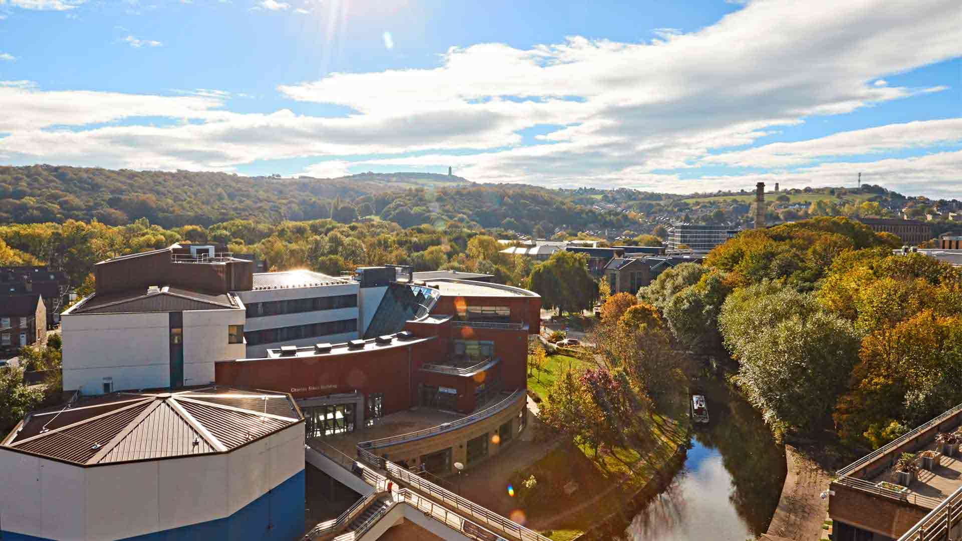 Charles Sikes Building on a sunny day. Picture shows the gree horizon along with the canal and lots of trees.